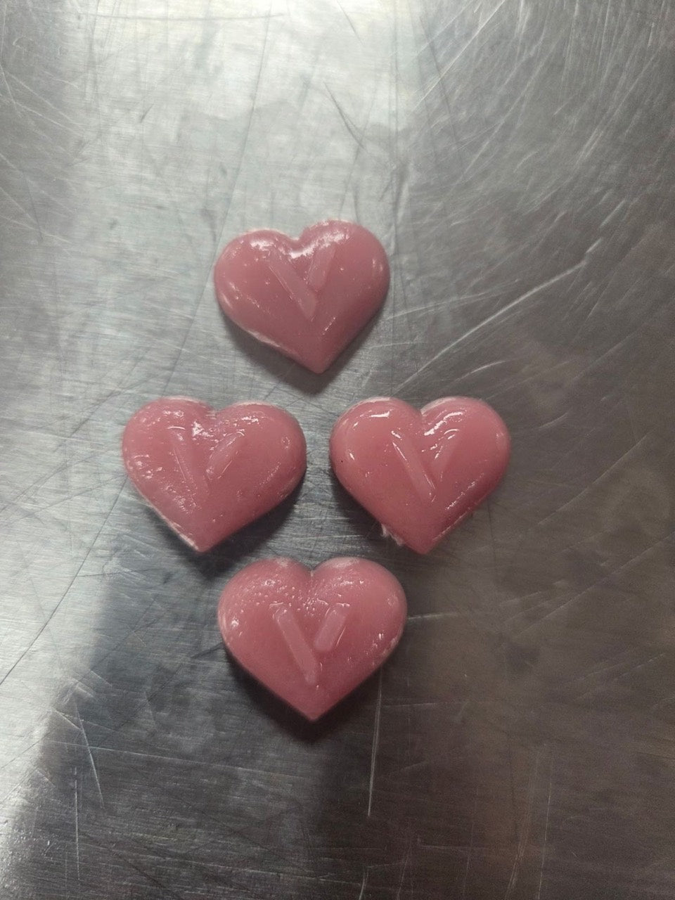 Actual pink heart-shaped VEYANA gummies with the V imprint